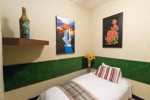 Un dormitorio con una cama con cabecero verde. en Xios Room, en Guayaquil