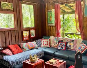 a living room with a blue couch with colorful pillows at Cabana Santa Premium in Rio de Janeiro