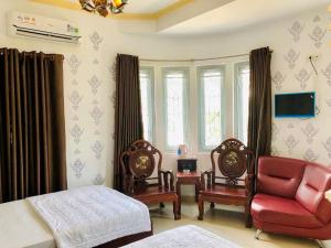 a bedroom with a bed and two chairs and a couch at Hong Tam Hotel in Ho Chi Minh City