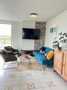 een woonkamer met een blauwe bank en een tv bij Villa Angeli in Les Sables-dʼOlonne
