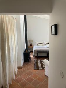 a bedroom with a bed and a window at Casa das Ameixas in Moncarapacho