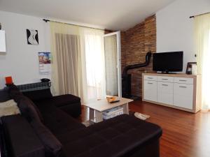 a living room with a couch and a flat screen tv at Apartments Paro in Pag