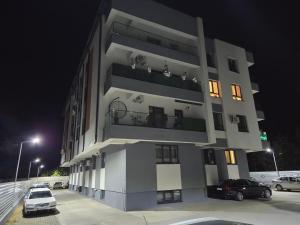 a building with cars parked in a parking lot at night at Apartament Magheru Residence in Craiova