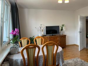 a dining room with a table with chairs and a television at Apartament Nad Jarem in Elblag