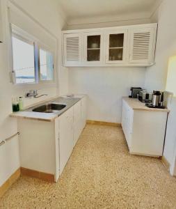 eine Küche mit weißen Schränken und einer Spüle in der Unterkunft CASA n'A COSTA in Trafaria