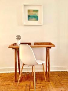 einen Holzschreibtisch mit einem weißen Stuhl in einem Zimmer in der Unterkunft CASA n'A COSTA in Trafaria + 17 Fotos