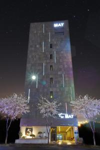 un edificio alto con un cartel en él por la noche en Hotel The May, en Gwangju