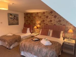 a hotel room with two beds and two lamps at The Balnoon Inn B&B in St Ives