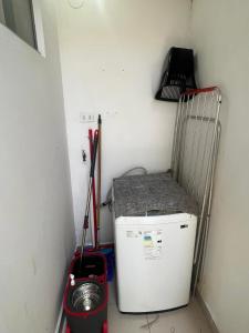 a small refrigerator in a corner with a shelf and tools at Hermoso Departamento Céntrico con piscina in Trinidad