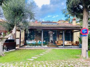 a house with glass doors and chairs on a yard at La Limonaia della Torretta Luxury Private Pool in Florence