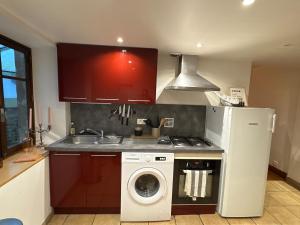 a kitchen with a washing machine next to a stove at La maison de Vouziers in Vouziers +11 photos