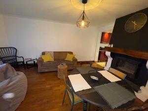 a living room with a table and a fireplace at La maison de Vouziers in Vouziers