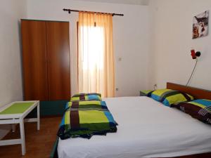 a bedroom with two beds and a table and a window at Apartments Paro in Pag