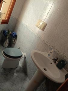 ein Badezimmer mit Toilette und Waschbecken in der Unterkunft Rena Majore Home in Rena Majore