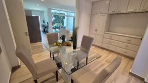 a dining room with a glass table and chairs at Ocean view private pool apartment near hotel facilities in Boca Chica