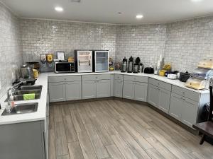 a large kitchen with white counters and appliances at Days Inn by Wyndham Liberal KS in Liberal