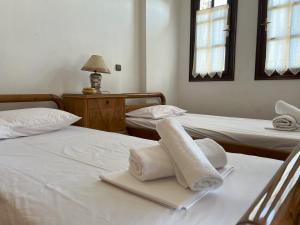 two beds in a room with towels on them at Villa Viviana in Milina