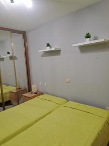 a bedroom with a green bed and a mirror at Chalet in Miengo with a community pool in Miengo +19 photos