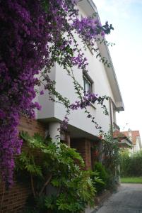a building with purple flowers on the side of it at Chalet in Miengo with a community pool in Miengo