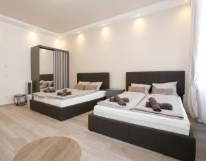 a bedroom with two beds and a mirror at LUX Prime Suite Vienna with FREE parking and FAST Internet 600 MBits in Vienna