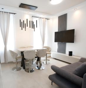 a living room with a table and chairs and a tv at LUX Prime Suite Vienna with FREE parking and FAST Internet 600 MBits in Vienna