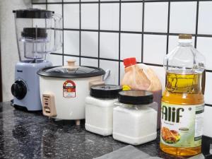 a kitchen counter with a blender and other ingredients at Dirgahayu Homestay II Nuri in Kulim