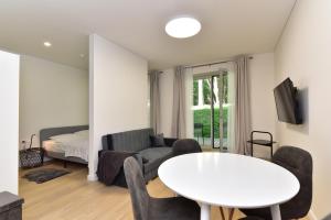 un soggiorno con un tavolo bianco e un divano di Apartamentai Eglė, Jūra, Smėlis a Juodkrantė