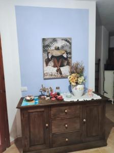 einem Holzschrank mit einem Bild darüber in der Unterkunft Rena Majore Home in Rena Majore