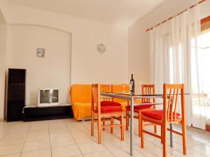 a dining room with a table and chairs and a tv at Apartments Paro in Pag
