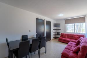 a living room with a table and a red couch at Departamento El Dorado in Santa Cruz Huatulco