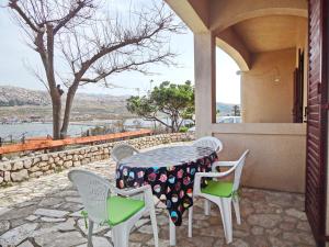 a table and chairs on a patio with a view at Apartments Paro in Pag