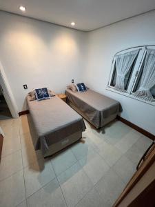 a room with two beds and a window at Cobertura com jacuzzi na enseada in Guarujá +13 photos