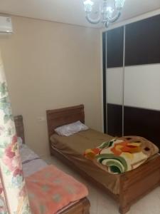 a bedroom with two beds and a chandelier at aggens immobiler nador in Nador