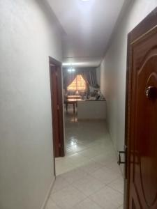 a hallway with a door and a room with a table at aggens immobiler nador in Nador