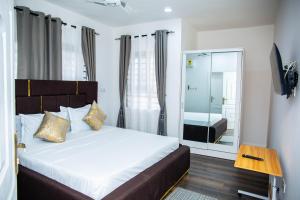 Un dormitorio con una cama grande y un espejo. en No4 Wisdom Court, en Accra