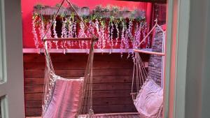 two hanging hammocks in a room with a red wall at La Plaza in Azul