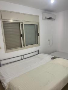 deux lits dans une chambre avec fenêtre dans l'établissement חופשה מושלמת על הכנרת, à Tel Aviv