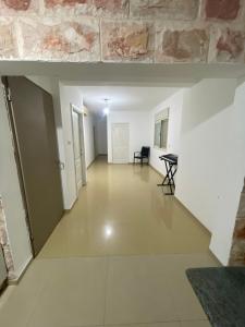 un long couloir avec des murs blancs et un mur en pierre dans l'établissement חופשה מושלמת על הכנרת, à Tel Aviv