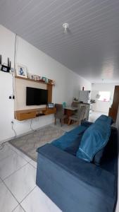 a living room with a blue bed and a tv at Casa da Estela in Barreirinhas