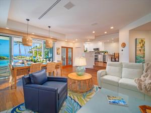 ein Wohnzimmer mit Sofa und Tisch in der Unterkunft Remodeled Beachfront Estate, Magnificent Mango Surf in Kihei