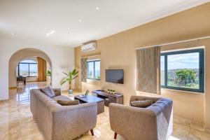 a living room with two couches and a tv at Spacious, Bright, Valley & Sea View Maisonette in Xagħra