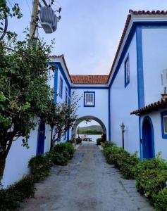 an alley in a blue building with an archway at Flat Luxuoso a 500 m da Praia do Forte em Cabo Frio in Cabo Frio +24 photos