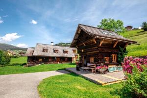 a log cabin with a porch and a house at Ferienhaus Napoleonvilla In Rennweg Am Katschberg in Aschbach