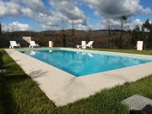 a swimming pool in the grass with two chairs around it at Eucalyptus Pink House in Covelo
