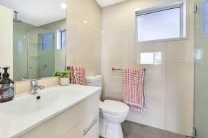 un bagno con un water, un lavandino e una finestra di Darwin Inner City Oasis 2 Bed Apt a Darwin