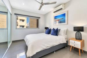 una camera da letto con un letto e una finestra di Darwin Inner City Oasis 2 Bed Apt a Darwin