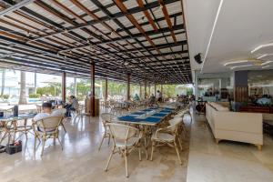 a restaurant with tables and chairs and people sitting at tables at Escapada 5 estrellas frente al mar - sonest morros in Cartagena de Indias