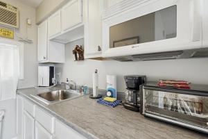 a kitchen counter with a sink and a microwave at The Bear's Den in Rockwood +16 photos