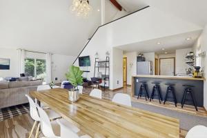 Una cocina y una sala de estar con una mesa y sillas de madera. en Cozy Coast Modern, en Nedonna Beach