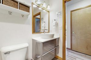 Un baño con lavabo, inodoro y espejo. en Cozy Coast Modern, en Nedonna Beach 29 fotos más